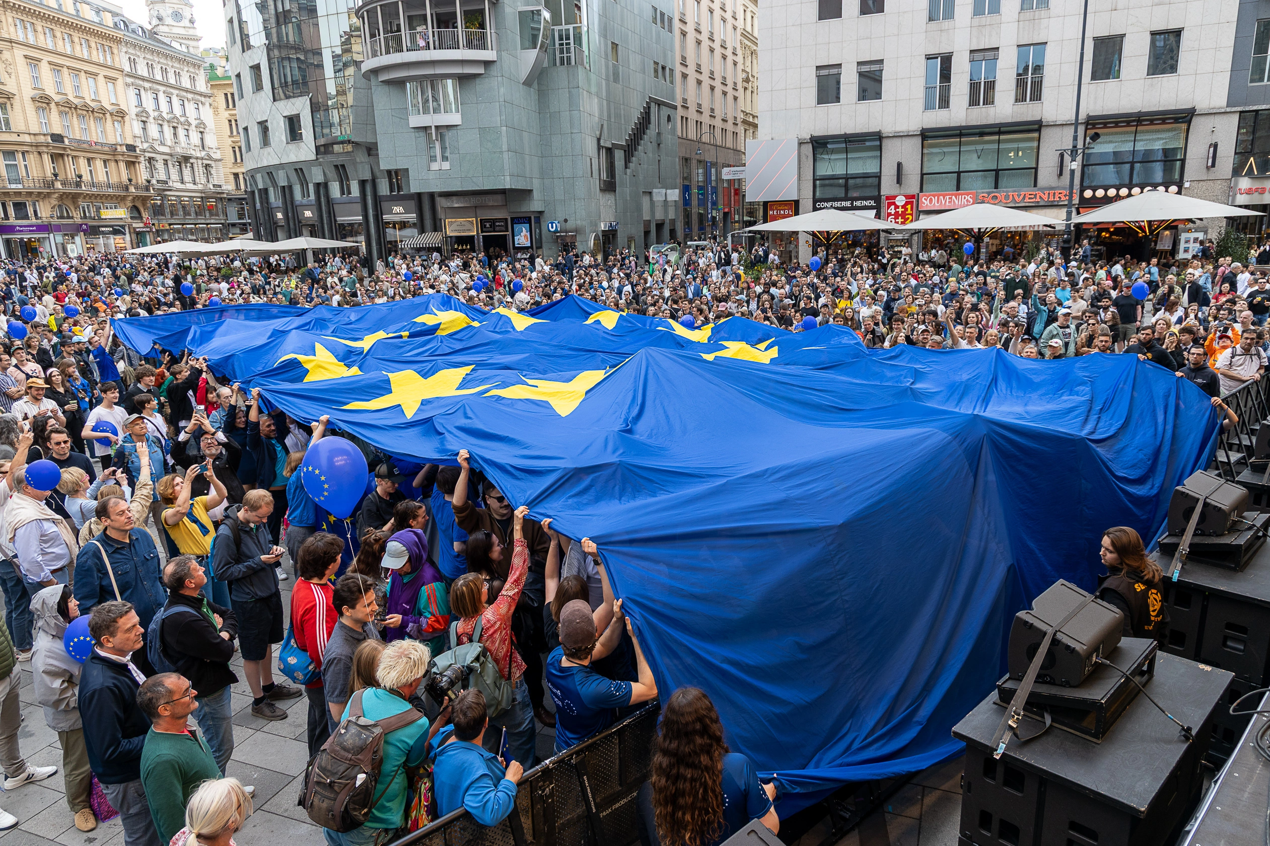 Die Europäische Kommission ruft auf, sich an der öffentlichen Konsultation gegen ungerechtfertigte Lieferbedingungen zu beteiligen. Diese führen zum Österreich-Aufschlag, der Waren verteuert. Die Bundesregierung hat dessen Beseitigung gefordert. Foto (Feiern am Europatag 2026 in Wien): Martin Lusser