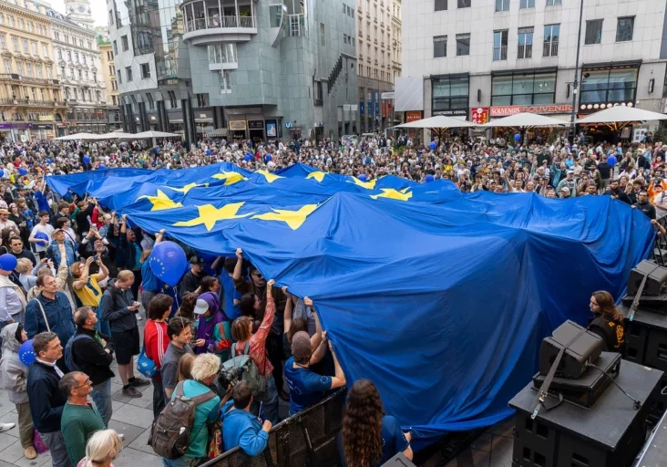 Die Europäische Kommission ruft auf, sich an der öffentlichen Konsultation gegen ungerechtfertigte Lieferbedingungen zu beteiligen. Diese führen zum Österreich-Aufschlag, der Waren verteuert. Die Bundesregierung hat dessen Beseitigung gefordert. Foto (Feiern am Europatag 2026 in Wien): Martin Lusser